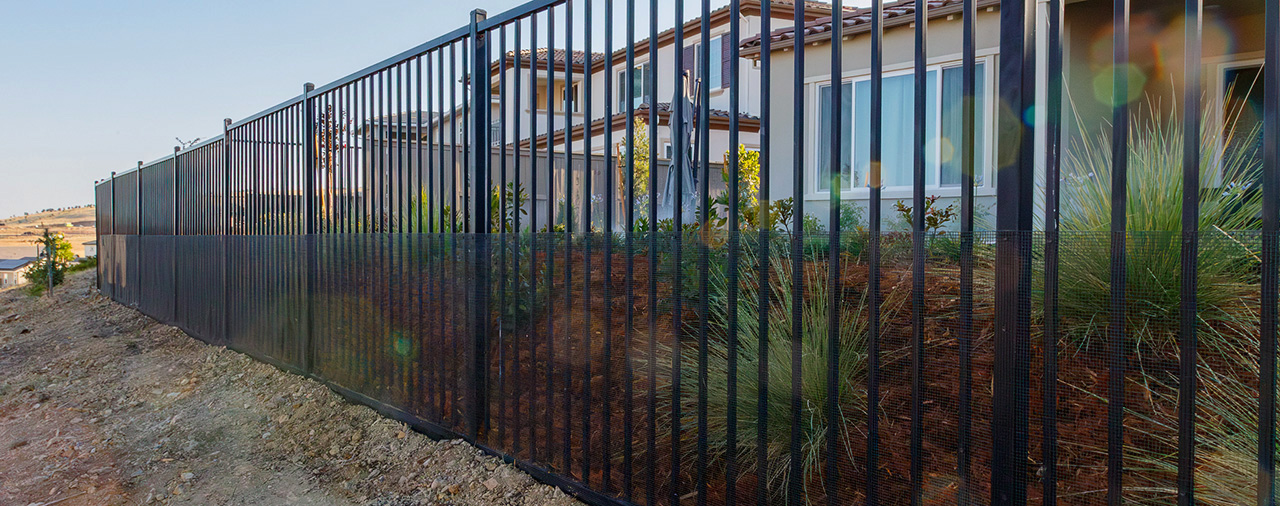 long stretch of mesh on wrought iron fence